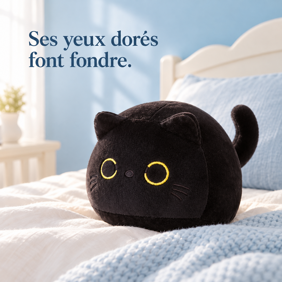 Peluche chat noir tout rond sur un lit d'enfant